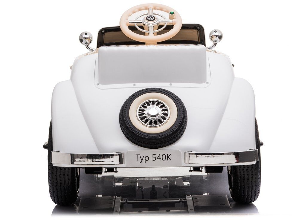 Weißes Spielzeugauto im Retro-Design, wie ein klassischer Mercedes-Benz 540K, von hinten. Mit Ersatzreifen auf der Heckklappe, Chromstoßstangen, runden Rückspiegeln. Cremefarbenes Lenkrad mit Stern sichtbar, auf weißem Hintergrund.