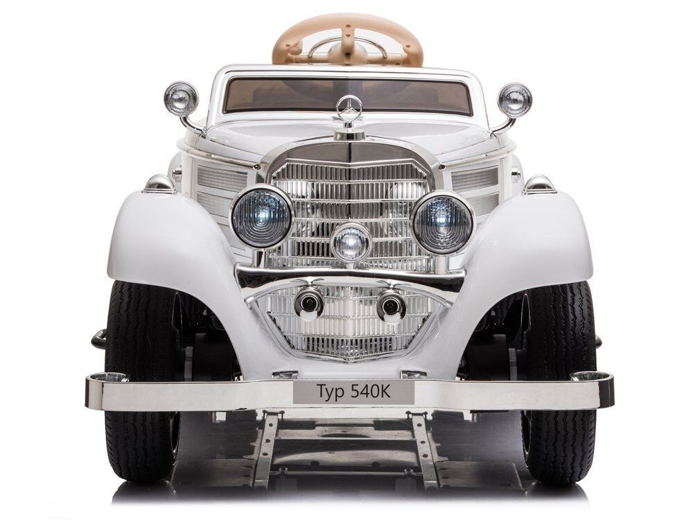 Vorderansicht eines weißen Oldtimer-Sportwagens im Stil des Mercedes-Benz 540K. Große verchromte Kühlerverkleidung, runde Scheinwerfer, breite Kotflügel und markante Stoßstange mit "Typ 540K". Goldbraunes Verdeck sichtbar.